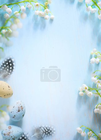 Easter eggs and Spring flower border on blue background; white spring blossom border; copy spac