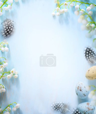 Foto de Huevos de Pascua y borde de flor de primavera sobre fondo azul; borde blanco de flor de primavera; copia spac - Imagen libre de derechos