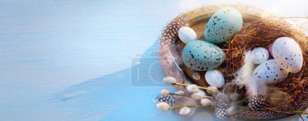 Easter holiday decoration on blue wooden background; sunny Easter mornin