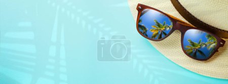 Téléchargez les photos : Concept vacances et bannière de voyage d'été. Joyeuses vacances sur la plage de sable tropical. Chapeau Panama et lunettes de soleil avec un reflet de la plage de sable trovic et des palmiers - en image libre de droit