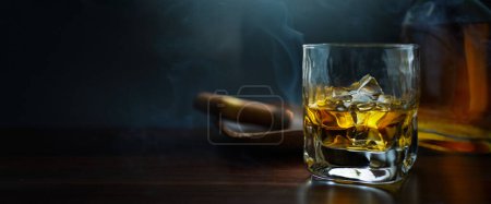Foto de Vaso de whisky, cigarro y botella; lujoso fondo de la bandera del club de los hombres con espacio de copia - Imagen libre de derechos