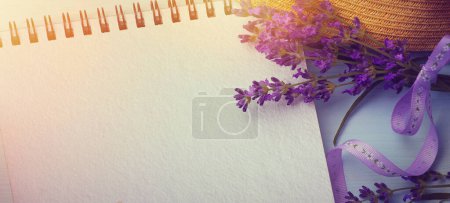 Photo for Blank writing book with summer flowers and a straw hat in the background, copy space. Flat lay with copy space - Royalty Free Image