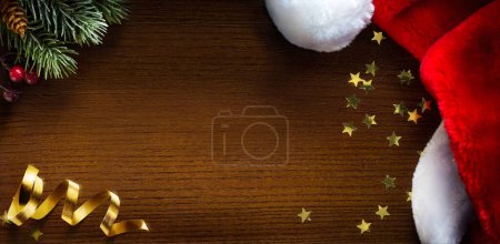 Téléchargez les photos : Bannière de Noël. branche d'arbre de Noël et chapeau de Père Noël sur fond en bois. Modèle large de bannière de Noël, en-tête, flyer - en image libre de droit