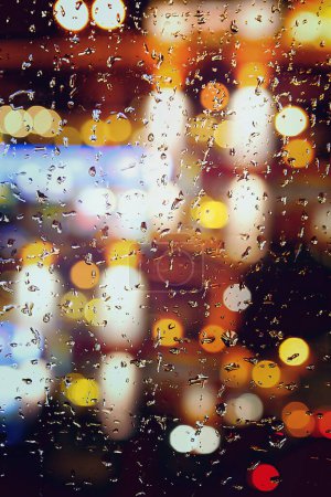 Foto de Fondo abstracto lluvia de otoño en la ciudad de la noche, gotas caen en la ventana en una noche de octubre - Imagen libre de derechos