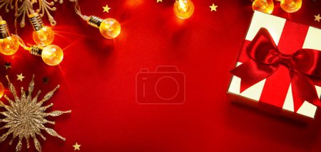 Foto de Tarjeta de felicitación de Navidad o fondo de la bandera con caja de regalo de Navidad de oro y decoración del árbol en fondo rojo - Imagen libre de derechos