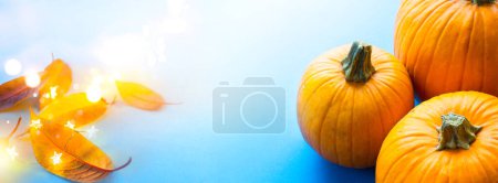 Téléchargez les photos : Bannière de fête de thanksgiving ou fond de carte de voeux avec citrouille d'automne et feuilles d'automne sur fond bleu - en image libre de droit