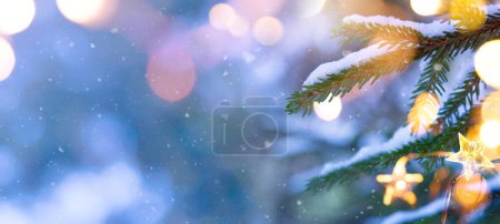 Foto de Cierre las ramas de abeto nevado de Navidad y la luz del árbol de Navidad. Marco de Navidad e invierno o concepto de frontera. Copia spac - Imagen libre de derechos