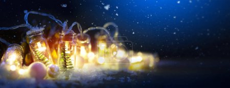 Foto de Decoración de la luz de vacaciones y el concepto de saludo - luces bokeh guirnalda de Navidad sobre fondo de invierno azul - Imagen libre de derechos