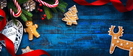 Foto de Tarjeta de felicitación de Navidad; Regalos dulces de Navidad, bastón de caramelo y hombre de jengibre - rama de abeto - Bandera de Navidad, encabezado, con espacio para copiar - Imagen libre de derechos