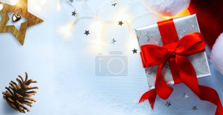 Foto de Tarjeta de felicitación de Navidad o fondo de banner con caja de regalo y sombrero de Santa Claus; espacio para copiar - Imagen libre de derechos