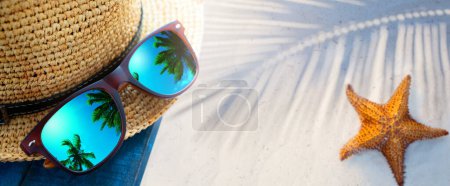 Téléchargez les photos : Abstract tropical sand beach from above with straw bucket hat and sunglasses, palm trees reflection, summer vacation concept banner with copy space, natural beauty outdoor spa - en image libre de droit