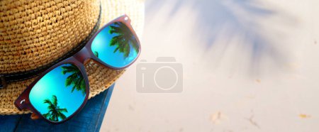 Foto de Abstract tropical sand beach from above with straw bucket hat and sunglasses, palm trees reflection, summer vacation concept banner with copy space, natural beauty outdoor spa - Imagen libre de derechos