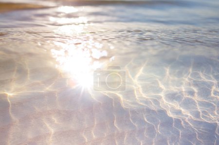 Foto de Fondo de agua abstracto. Textura de la costa del océano. Bokeh luz del atardecer en la playa del mar de verano - Imagen libre de derechos