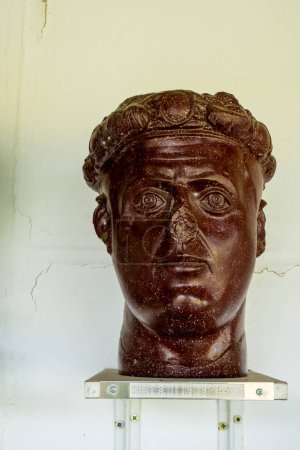 Téléchargez les photos : Gamzigrad, Serbie - 11 août 2021 : L'empereur Galerius tête en porphyre, de son palais Felix Romuliana à Gamzigrad, Serbie. C'est un site du patrimoine mondial de l'UNESCO depuis 2007. - en image libre de droit