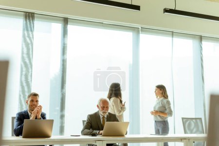 Photo for Group of businessmen and businesswomen working together in office - Royalty Free Image