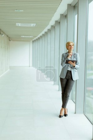 Photo for Businesswoman using digital tablet on the modern office hallway - Royalty Free Image