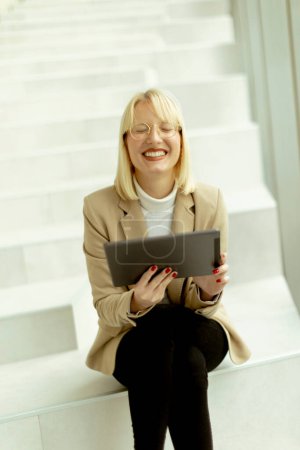 Photo for Businesswoman working on digital tablet on the modern office stairs - Royalty Free Image