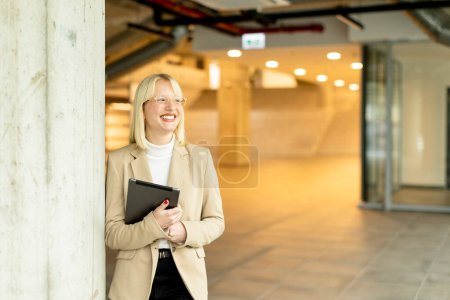 Foto de Mujer de negocios con tableta digital en el pasillo de la oficina moderna - Imagen libre de derechos