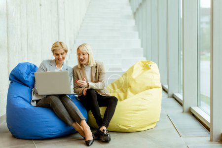 Photo for Two businesswomen working on laptop on lazy bags in the modern office - Royalty Free Image