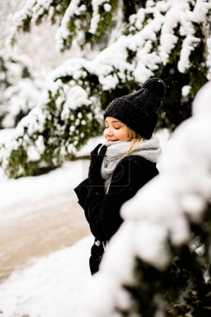 Photo for Pretty young woman in warm clothes enjoying in snow - Royalty Free Image