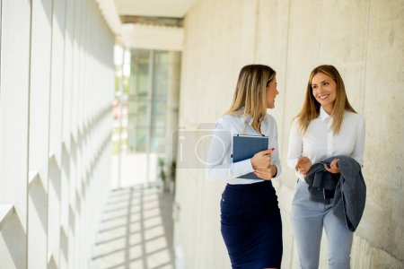 Foto de Dos mujeres de negocios jóvenes lindos caminando por las escaleras en el pasillo de la oficina - Imagen libre de derechos