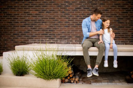 Téléchargez les photos : Père et sa jolie fille passent un bon moment devant la porte de la maison - en image libre de droit