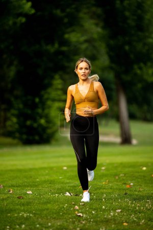 Photo for Pretty young woman running in park - Royalty Free Image