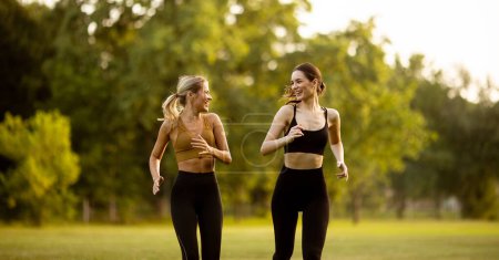 Photo for Two pretty young women running in the park - Royalty Free Image
