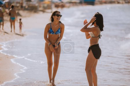 Photo for Two pretty young woman having fun on the seaside at hot summer day - Royalty Free Image