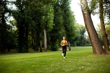 Photo for Pretty young woman running in park - Royalty Free Image