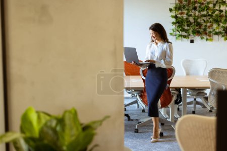 Photo for Pretty young business woman with laptop in the office hallway - Royalty Free Image