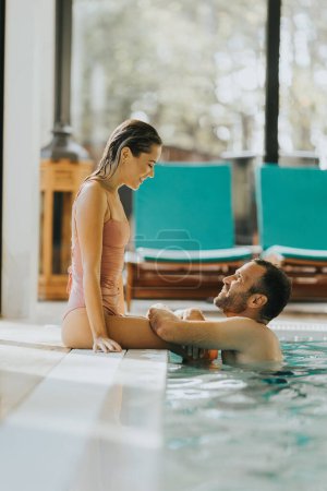 Foto de Hermosa pareja joven relajándose en la piscina cubierta - Imagen libre de derechos