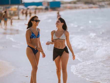 Foto de Dos guapas jóvenes divirtiéndose en la playa en el caluroso día de verano - Imagen libre de derechos