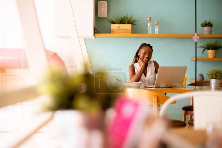 Photo for Aoung African american woman working on a laptop and having a healthy breakfast in the cafe - Royalty Free Image