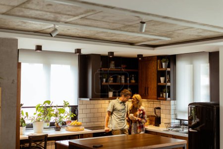 Foto de Escena conmovedora se desarrolla en una cocina doméstica como una pareja comparte un abrazo cariñoso, rodeado de la tranquilidad de su casa al final del día - Imagen libre de derechos