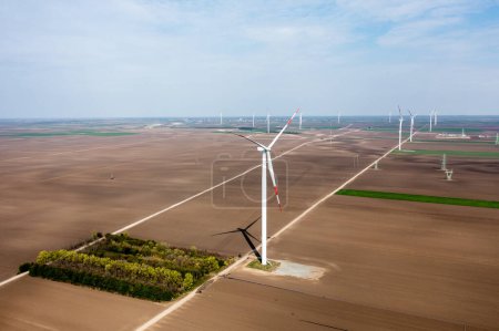 Foto de Fila tras fila de imponentes turbinas eólicas dominan el paisaje, cosechando energía al amanecer - Imagen libre de derechos