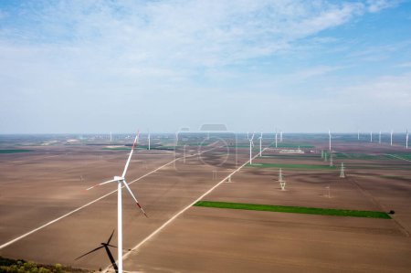 Photo for Row upon row of towering wind turbines dominate the landscape, harvesting energy as day breaks - Royalty Free Image