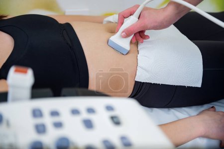 Téléchargez les photos : Un professionnel de la santé effectue une échographie sur un abdomen de patients, révélant les mystères du corps. - en image libre de droit
