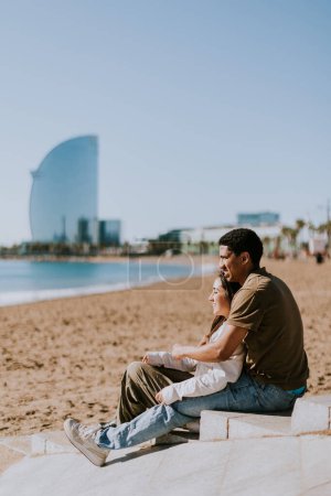 Foto de Pareja se relaja en las playas de arena de Barcelonas, con el icónico hotel en el fondo - Imagen libre de derechos
