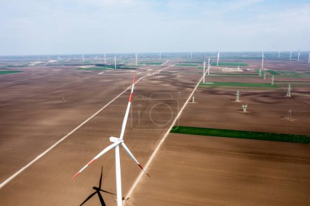 Foto de Fila tras fila de imponentes turbinas eólicas dominan el paisaje, cosechando energía al amanecer - Imagen libre de derechos