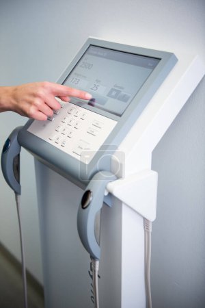Photo for A healthcare professional calibrates advanced medical equipment. - Royalty Free Image