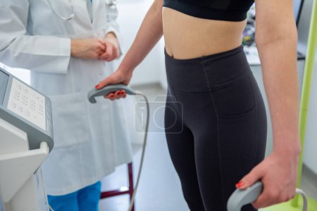 Photo for A health practitioner assists a woman with a body composition test using advanced equipment. - Royalty Free Image