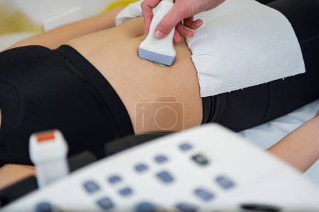 A healthcare professional conducts an ultrasound scan on a patients abdomen, revealing the mysteries of the body.