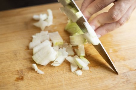 Photo for Man hands cutting onion close up on wooden board at home kitchen - Royalty Free Image