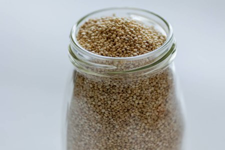 Téléchargez les photos : Quinoa dans un bocal en verre près sur fond blanc - en image libre de droit