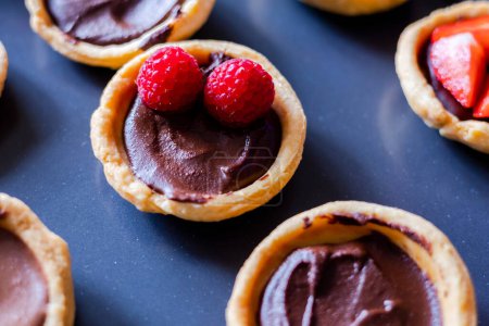 Photo for Chocolate-Berry Mini Tarts Close-Up on Tray - Royalty Free Image