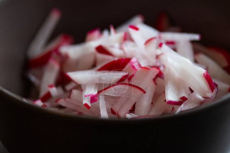crunchy radish delight: fresh slices in brown bowl close-up