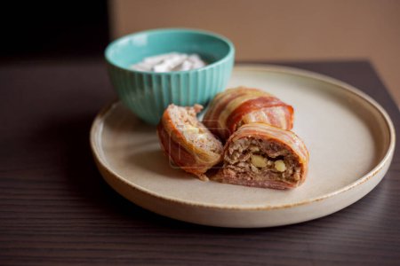 savory delight: delicious dish with meatballs wrapped in bacon, filled with mozzarella and yogurt sauce