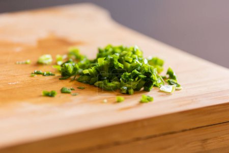 fresh chop green onion on wooden board close-up
