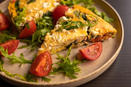delicious spring frittata for a perfect brunch with arugula and cherry tomatoes close-up